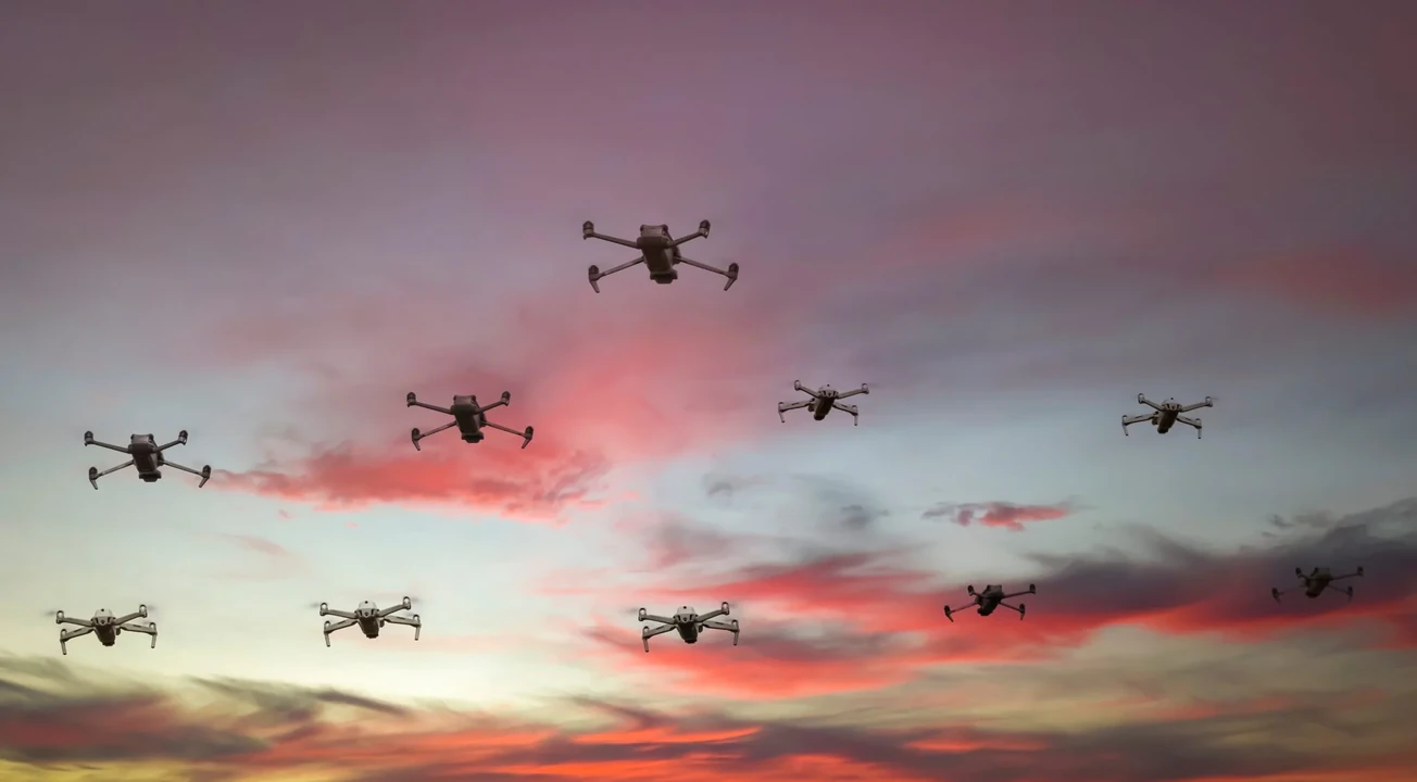 Multiple commercial-style drones flying together at sunset, illustrating coordinated drone activity and swarm-based security threats.