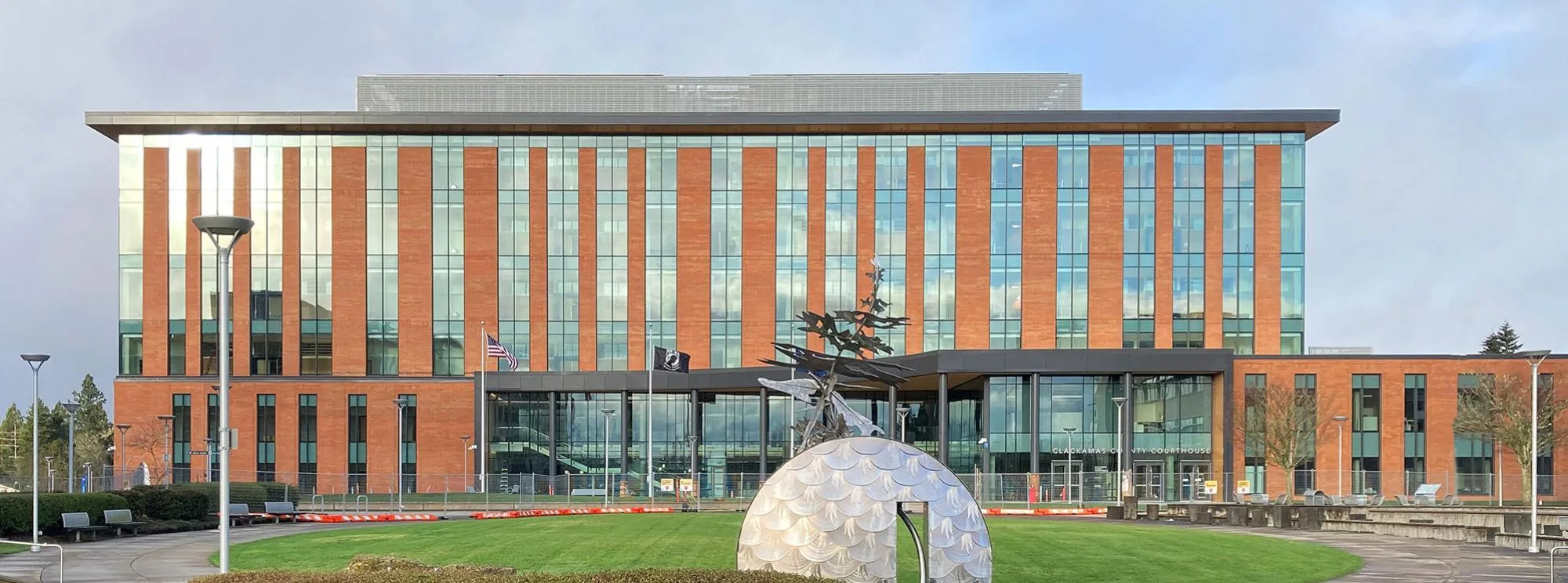 Clackamas County Circuit Courthouse exterior lawn with sculptures and flags